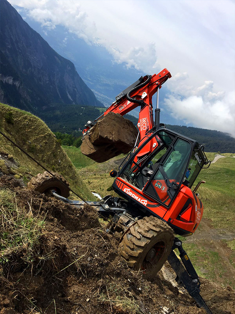 Une pelle araignée EuroMach stabilisée sur un flanc de montagne escarpé.